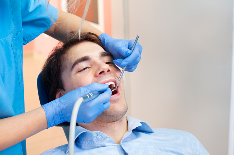 Man receiving dental cleaning at Reich Dental Center – Roswell in Roswell, GA.