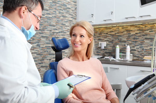 Woman talking to dentist before her oral cancer screening at Reich Dental Center – Roswell.