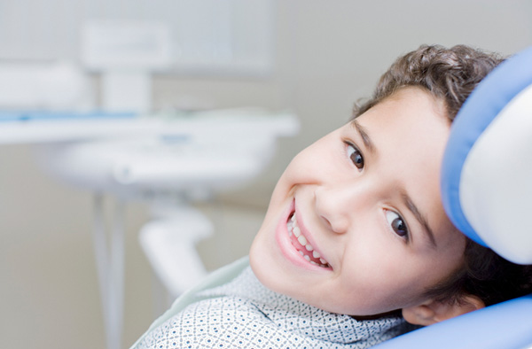 Young boy smiling with healthy teeth after getting dental sealants at Reich Dental Center – Roswell.