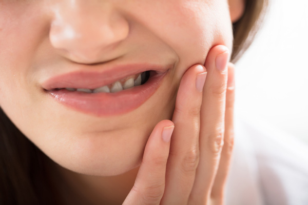 Woman with dental pain due to impacted wisdom tooth